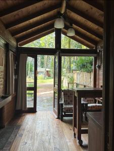 un soggiorno con pavimento in legno e una grande porta a vetri di Cabaña Ceibo a Mar de las Pampas