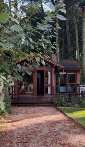 una casa nel bosco con un portico di Cabaña Ceibo a Mar de las Pampas Altre 5 foto