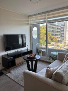 コンセプシオンにあるDepartamento nuevo cerca de Sanatorio Alemánのソファ、テレビ、テーブルのあるリビングルーム