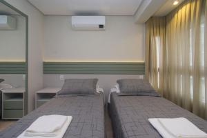 a bedroom with two beds and a mirror at Apartamento Luxo em Bento Gonçalves in Bento Gonçalves +27 photos