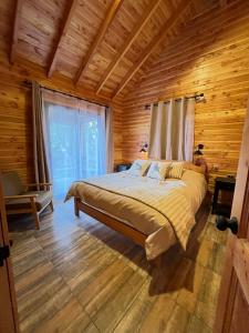 a bedroom with a bed in a wooden cabin at Alto Terralis in Minetué