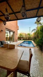 a patio with a table and a swimming pool at Exceptional Marrakech Villa 5 Bedrooms & Pool in Oulad Akkou