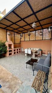 a patio with a table and chairs and a table and benches at Exceptional Marrakech Villa 5 Bedrooms & Pool in Oulad Akkou