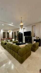 a large living room with a large green couch at Exceptional Marrakech Villa 5 Bedrooms & Pool in Oulad Akkou