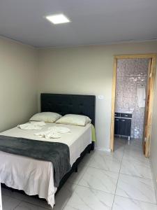 a bedroom with a large bed with white sheets at Pousada e Restaurante Zanella in Candói