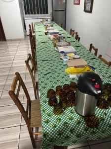 a long table with a green table cloth with food on it at Pousada e Restaurante Zanella in Candói