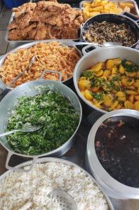 a table with many different types of food in pans at Pousada e Restaurante Zanella in Candói