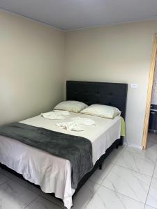 a bed with a black headboard in a room at Pousada e Restaurante Zanella in Candói +3 photos