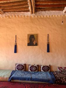 TagouniteBouhayat desert camp Tagounite的一间配有沙发的客房,墙上挂着一张照片