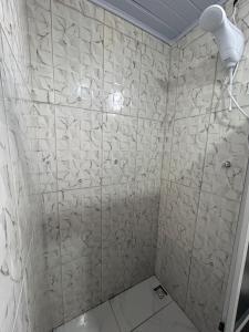 a bathroom with a shower with white tiles at Pousada e Restaurante Zanella in Candói