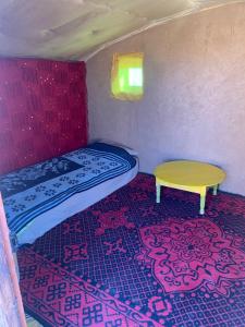 TagouniteBouhayat desert camp Tagounite的一间有一张床和一张桌子的小房间
