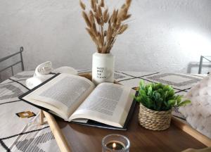 an open book on a table with a vase at Azores Panorama Lodge in Norte Pequeno