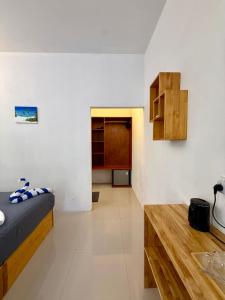 a bedroom with a bed and a wooden table at The Wave Dhigurah in Dhigurah