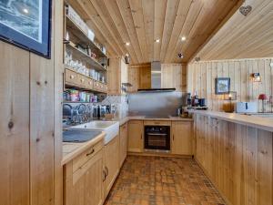 a large kitchen with wooden cabinets and a sink at Appartement 6 pers, balcon, wifi à Tignes - FR-1-502-583 in Tignes