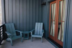 twee blauwe stoelen en een tafel op een veranda bij The Jackalope Rooftop w Fire Pit & Epic Mountain Views in Buena Vista