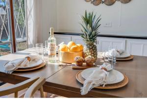 a table with plates and a pineapple and a bottle of wine at The Cozy Jamozy in Panama City Beach