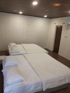 ein Schlafzimmer mit zwei Betten mit weißer Bettwäsche in der Unterkunft Aetheria Estate Retreat in Chikmagalur