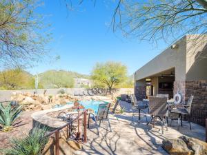 a patio with a table and chairs and a pool at Desert Mountain Majesty - Private Spa&Guest Casita in Cave Creek