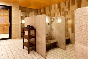 a bathroom with a shower and a refrigerator at Dormy Inn Nagano in Nagano