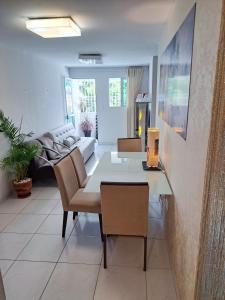 ein Wohnzimmer mit Tisch und Couch in der Unterkunft Quarto Individual para 3 Pessoas em AP Compartilhado in João Pessoa + 14 Fotos