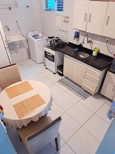 eine Küche mit Tisch, Spüle und Herd in der Unterkunft Quarto Individual para 3 Pessoas em AP Compartilhado in João Pessoa