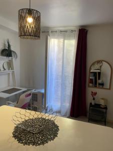 a room with a table and a mirror and a window at Studio calme au centre-ville in Manosque