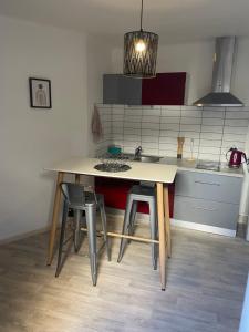a kitchen with a table and chairs and a sink at Studio calme au centre-ville in Manosque +3 photos