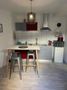 a kitchen with a table and some stools in it at Studio calme au centre-ville in Manosque