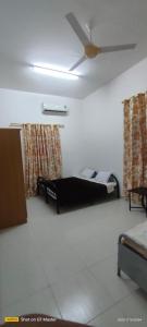 a room with two beds and a ceiling fan at Home of turtles in Al Ḩadd