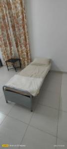 a small bed in a room with a window at Home of turtles in Al Ḩadd