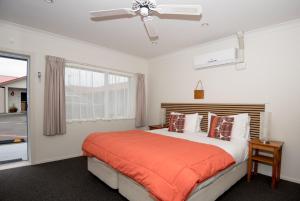 a bedroom with a bed and a ceiling fan at AhiKaa Gisborne Motel in Gisborne