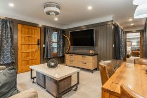 ein Wohnzimmer mit Fernseher und Tisch in der Unterkunft Cedar Crest - Osprey Cottage 3 in Homewood