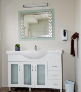 a bathroom with a sink and a mirror at AhiKaa Gisborne Motel in Gisborne