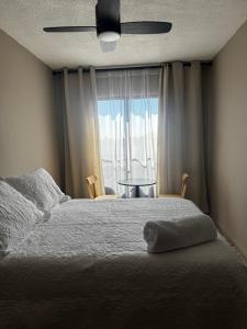 a bedroom with a bed and a window with a table at CASA UMBRAL - Plaza principal in Lagos de Moreno