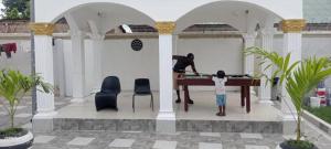 Cutting Edge Guest House في Daranka: رجل وصبي يلعبان تنس الطاولة