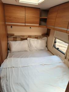 1 cama blanca grande en una habitación pequeña en كرفان لحظة لقاء, en Al Ula