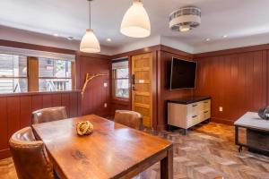 ein Esszimmer mit einem Holztisch und einem TV in der Unterkunft Cedar Crest - Robin Cottage 6 in Homewood