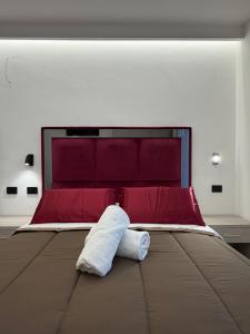 a bedroom with a large bed with red and white pillows at D'ANNUNZIO suites in Martinsicuro