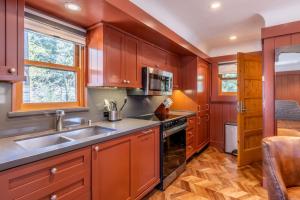 eine Küche mit Holzschränken und einer Spüle in der Unterkunft Cedar Crest - Robin Cottage 6 in Homewood