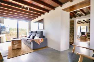 a living room with a couch and a large window at The Cliffs - Picon Seaside Cottage in Loiba