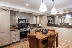 eine Küche mit einem Holztisch und Stühlen in der Unterkunft Cedar Crest - Sparrow Cottage 1 in Homewood