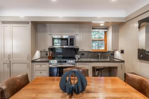 eine Küche mit einem Holztisch mit Stühlen und einer Tableasteryasteryasteryastery in der Unterkunft Cedar Crest - Sparrow Cottage 1 in Homewood