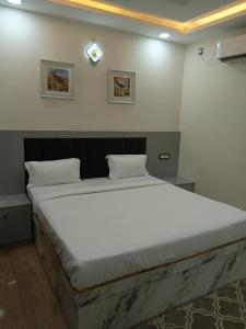 a large bed in a room with a clock on the wall at The Prahas resort in Dabra