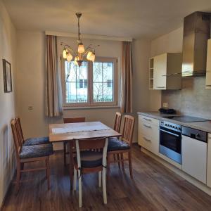 eine Küche mit einem Holztisch und Stühlen und einem Tisch und einem Esszimmer in der Unterkunft Ferienwohnung Ruth in Breitenwang