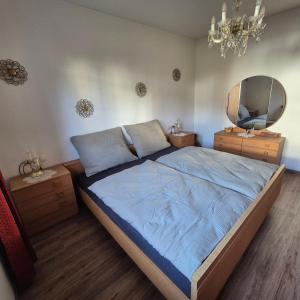 ein Schlafzimmer mit einem großen Bett und einem Spiegel in der Unterkunft Ferienwohnung Ruth in Breitenwang + 3 Fotos