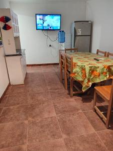 a dining room with a table and a tv on the wall at Hostal Ribera de Quitor in San Pedro de Atacama