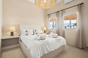 une chambre blanche avec un grand lit avec une fenêtre dans l'établissement Templo Sotogrande, à Sotogrande 83 autres photos