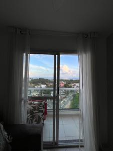 Cette chambre dispose d'une fenêtre offrant une vue sur la ville. dans l'établissement Quarto apartamento em Guarapari, à Guarapari 2 autres photos