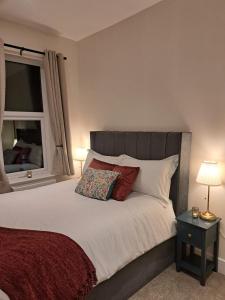 ein Schlafzimmer mit einem großen Bett mit Fenster in der Unterkunft Central Park View - Modern & Stylish 2 Bed Apartment - Great Location in Scunthorpe