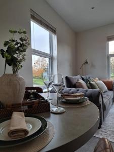 ein Wohnzimmer mit einem Sofa und einem Tisch mit Weingläsern in der Unterkunft Central Park View - Modern & Stylish 2 Bed Apartment - Great Location in Scunthorpe + 9 Fotos